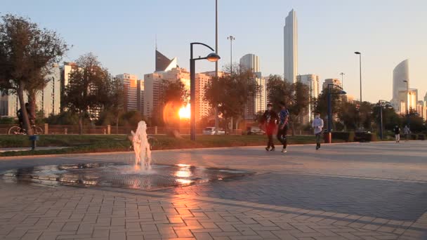 ABU DHABI, Emirados Árabes Unidos - 6 de abril de 2021: Pessoas em Corniche correndo e andando ao pôr do sol em Abu Dhabi — Vídeo de Stock