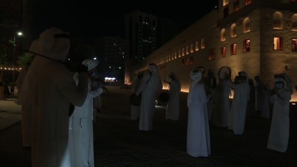 ABU DHABI, Zjednoczone Emiraty Arabskie - MAJ 15, 2021: Tradycyjny męski taniec Emiratów Arabskich Al Ayala w Qasr Al Hosn w nocy świętujący Eid Holidays — Wideo stockowe