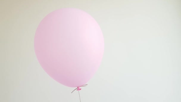 Leichtes Heliumballon in rosa schwebend gegen weiße Wand, Feier, Geburtstagskonzept — Stockvideo