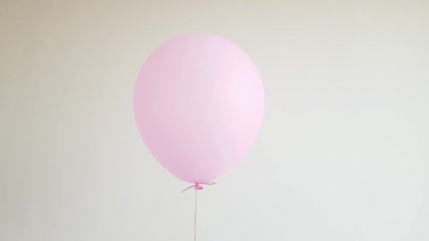 Leichtes Heliumballon in rosa schwebend gegen weiße Wand, Feier, Geburtstagskonzept — Stockvideo