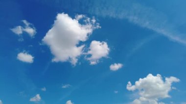 Açık güneşli yaz gününde mavi gökyüzünde hareket eden zaman bulutları