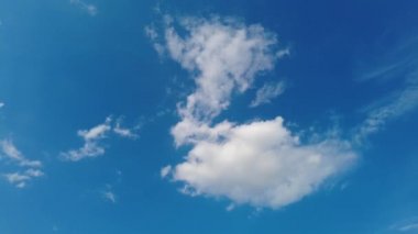Güneşli yaz gününde mavi gökyüzünde hareket eden bulutlar