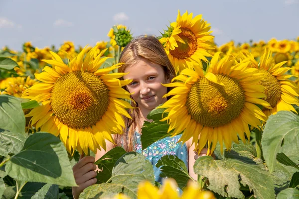 Девушка с улыбкой, окруженная яркими цветущими подсолнухами. Поколение Z. — стоковое фото