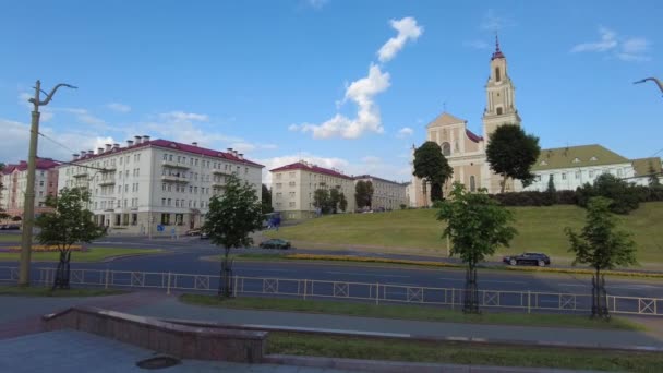 Grodno, Weißrussland - 24. Juli 2021: Zeitraffer des Straßenverkehrs in Grodno mit der berühmten Bernhardinerkirche im Hintergrund — Stockvideo