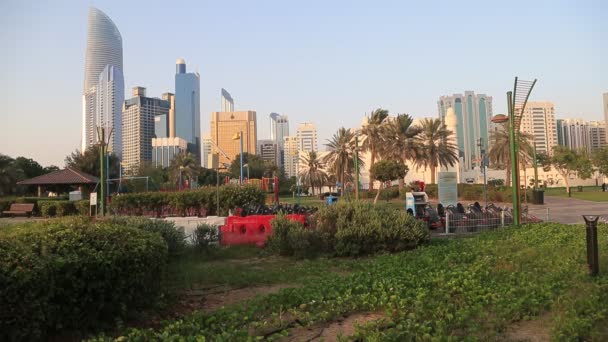 ABU DHABI, Emiratos Árabes Unidos - 23 de mayo de 2021: Abu Dhabi Family park on Corniche during golden hour. Gente caminando. — Vídeo de stock