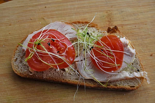 Jambonlu sandviç, domates ve pırasa filizi.