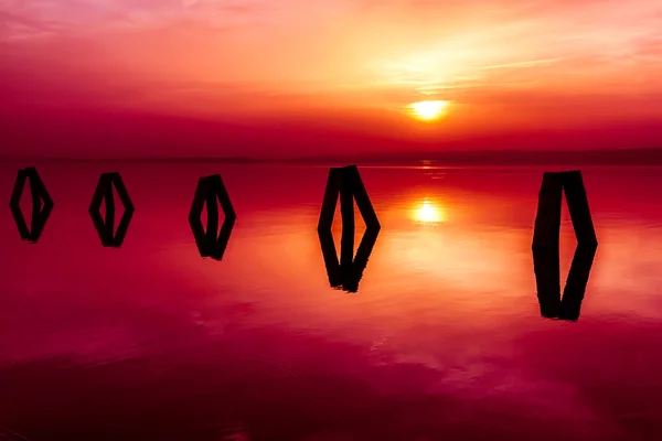 Houten pilaren in water dicht bij de vuurtoren — Stockfoto