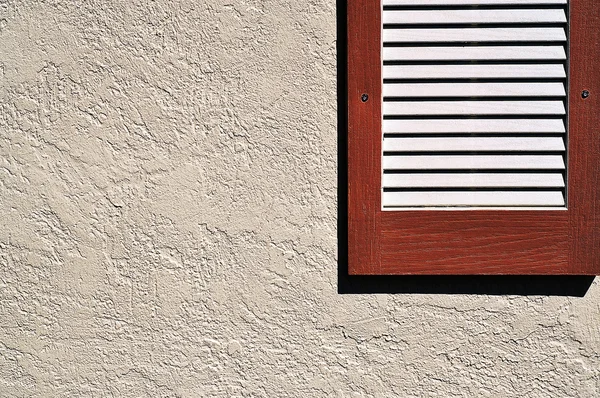 Red Shutter on Stucco Exterior Wall