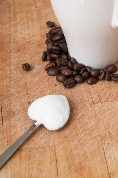 Taza de café con azúcar en una cuchara en forma de corazón — Foto de Stock