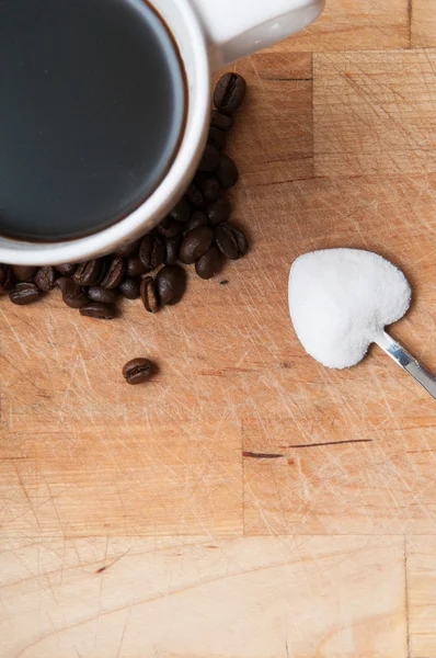 Taza de café con azúcar en una cuchara en forma de corazón — Foto de Stock