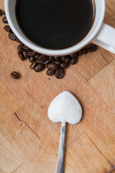 Taza de café con azúcar en una cuchara en forma de corazón — Foto de Stock