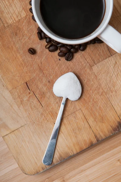 Taza de café con azúcar en una cuchara en forma de corazón — Foto de Stock