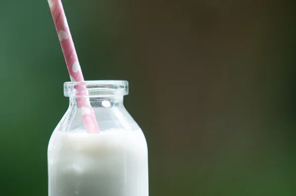 Botella de leche sobre un fondo coloreado — Foto de Stock