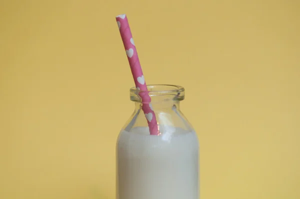 Melk fles op een gekleurde achtergrond — Stockfoto