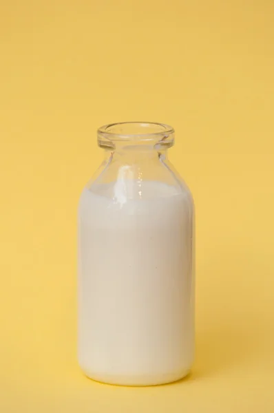 Botella de leche sobre un fondo coloreado — Foto de Stock