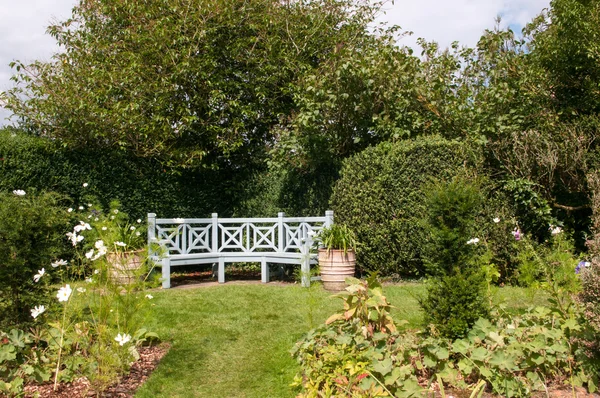 Garden bench in a sunny garden — Stock Photo, Image
