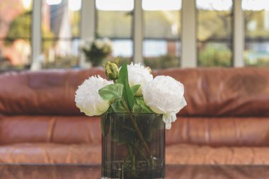 Şık bir odanın içindeki masanın üstünde suni çiçeklerden oluşan zarif bir buket.