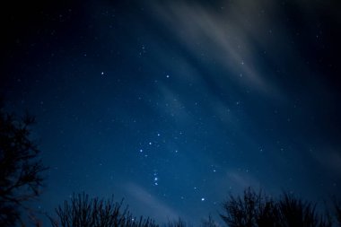 Gökyüzünde bulutların hareket ettiği yıldızların görüntüsü gökyüzünde akroolarla hareket ediyor.