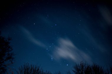 Gökyüzünde bulutların hareket ettiği yıldızların görüntüsü gökyüzünde akroolarla hareket ediyor.