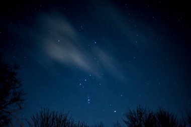 Gökyüzünde bulutların hareket ettiği yıldızların görüntüsü gökyüzünde akroolarla hareket ediyor.