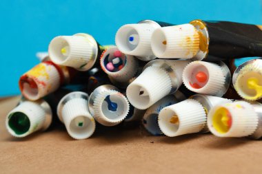 Kağıt arkaplanda çeşitli renkler olan sanat tüpleri.