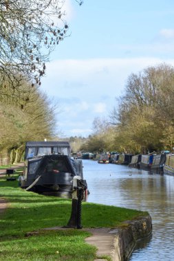 Kanal teknesi ya da dar bir tekne güneşli bir günde bir kanalın kıyısına demir atmış.