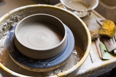 Seramik aletleriyle çömlekçilik atölyesinde kilden sanat aletleri yapmak için.