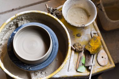 Seramik aletleriyle çömlekçilik atölyesinde kilden sanat aletleri yapmak için.
