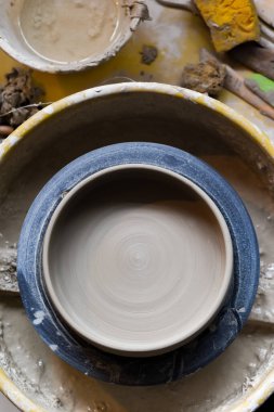 Seramik aletleriyle çömlekçilik atölyesinde kilden sanat aletleri yapmak için.