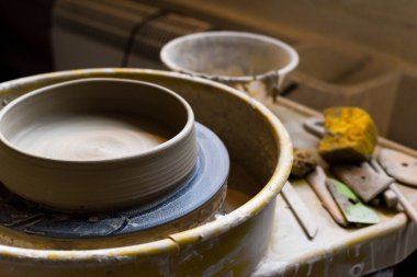 Seramik aletleriyle çömlekçilik atölyesinde kilden sanat aletleri yapmak için.