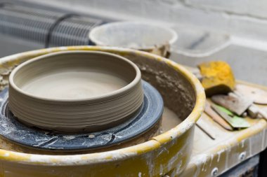 Seramik aletleriyle çömlekçilik atölyesinde kilden sanat aletleri yapmak için.