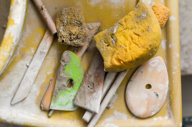 Seramik aletleriyle çömlekçilik atölyesinde kilden sanat aletleri yapmak için.