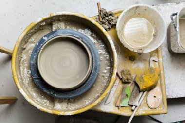 Seramik aletleriyle çömlekçilik atölyesinde kilden sanat aletleri yapmak için.