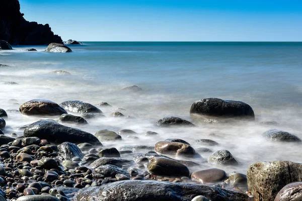 Спокійний Кам Янистий Пляж Тривалим Впливом Спокійної Блакитної Води — стокове фото