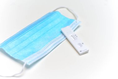 Beyaz arkaplanda covid-19 virüsü ve yüz maskesi kontrolü için ek akış testi