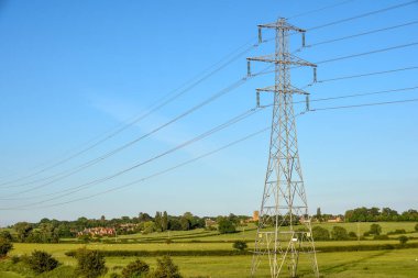 Mavi gökyüzü manzarası üzerinde kablolar olan elektrik direği kulesi