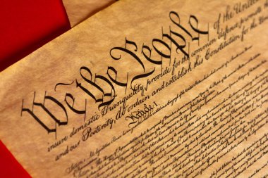 A parchment of the Constitution with a red background clipart