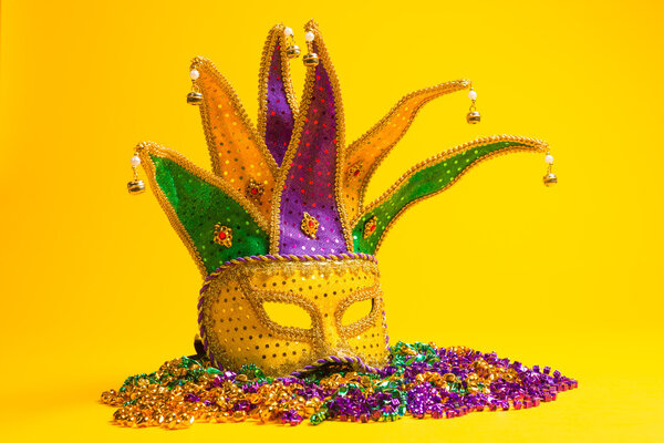 Colorful group of Mardi Gras or venetian mask or costumes on a yellow background