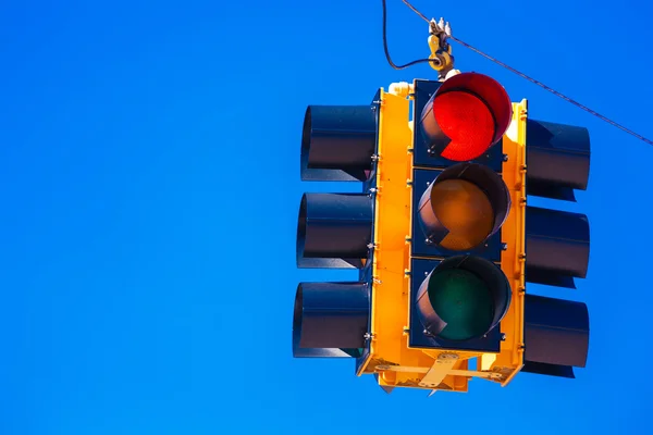 Um semáforo vermelho com um fundo azul céu — Fotografia de Stock