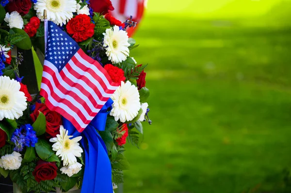 En vacker blomsterkrans och en flagga på minnesdagen Stockbild