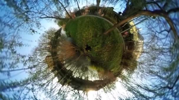 Homem turista no parque verde esférico Panorama pessoas estão montando de bicicleta caminhantes verde fresco grama edifícios dia ensolarado vídeo para realidade virtual Cityscape — Vídeo de Stock