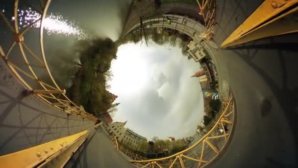 Spaziergänger und Autos auf einer Brücke durch Fluss vr video 360 kleine Planeten video cars are driven vintage buildings smooth river cityscape clouds blue sky — Stockvideo