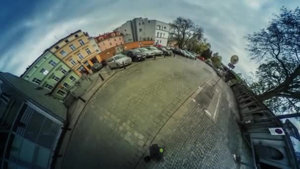 Люди в старом городе Автомобили на дороге против видео 360 Маленькая планета Видео старинные здания Машины управляются тротуары городской пейзаж плавающие облака голубое небо — стоковое видео