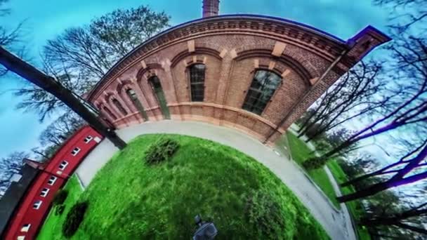 Červené cihly Archs alej v Green parku vr Video 360 malé planety Video jeho získání čerstvé zelené trávy trávník budovy jsou za holé rozvětvené kvádry — Stock video