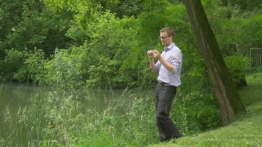 Sanal Tablet Won ile Man Lake Bank Man Onun Fist İşadamı Yükseltir Forex Alışveriş Güneşli Yaz Günü Yapıyor Su Yanında Çalışıyor