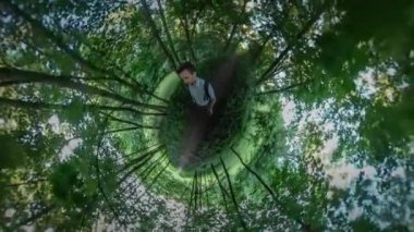 360vr Video adam kendini Park sokak yeşil video çekme ağaçlar tarafından patika güneş parlar aracılığıyla dalları adam turist Backpacker ağaçları arasında yürüyüş.