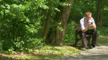 Parkta Cep Telefonu ile Man Bir Bankta Oturan Bir Akıllı Telefon Holding Mesajlaşma Mesajlaşma Doğa Taze Yeşil Ağaçlar Sunny Yaz Günü Zaman geçirin