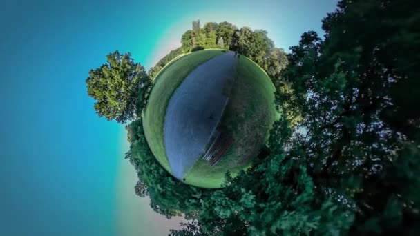 360Vr Video Hombre consigue en una bicicleta a caballo de distancia Personas mochilero turista en la carretera en Park Bench by Park Alley Green Trees Grass Sunny Day Sunset Blue Sky — Vídeos de Stock