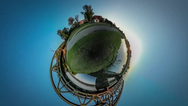 은행 금속 다리 구체적인 지원 그린 슬로프 일몰 파란 하늘 여름 화창한 날에 다리 집 마을 의해 360vr 비디오 남자 실행 기차를 타고 — 비디오