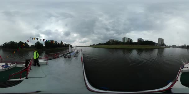 360 vr Vidéo Bateau de loisirs flotte près de la rivière Homme lentement en veste jaune marche sur un pont supérieur Voyageant par la rivière Odra dans les nuages épais d'Opole 